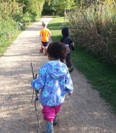Small children walking on a path, indicating nature-based early learning