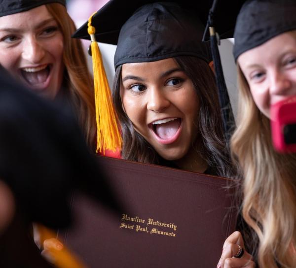Students taking selfies at Commencement