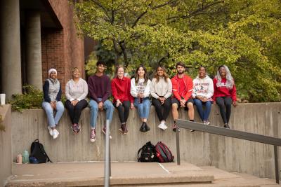Hamline students sitting on a wall