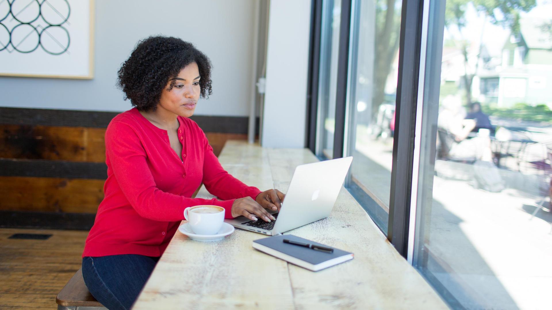 Hamline online degree completion student working in coffeeshop